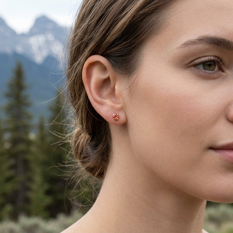 Full-body shot of a model outdoors showcasing a small silver sunstone ring on her hand amidst natural pine and mountain scenery.
