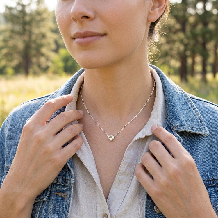 Macro shot of tiny Champagne Sunstone in silver bezel, on neutral surface emphasizing its micro-texture and clarity.