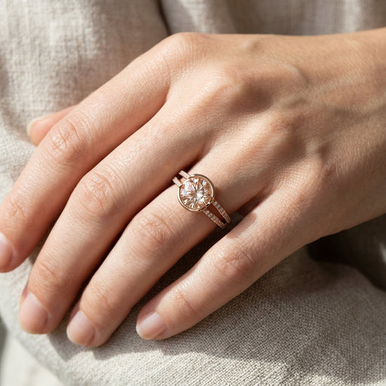 Stylized close-up of a rose gold ring with Oregon Sunstone against textured linen fabric, highlighting sparkle and texture.
