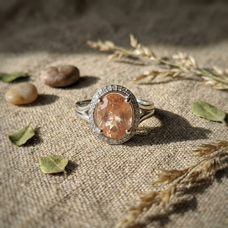 Flat lay of the Sunstone Halo Ring on rustic linen fabric with natural elements, emphasizing organic theme and detailed micro-texture.