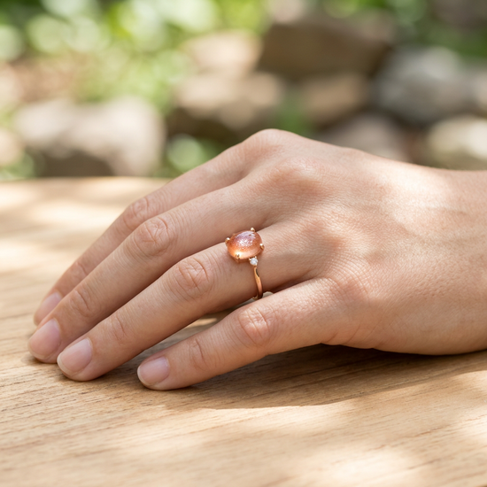 Close-up of the Odyssey Cabochon Ring on a smooth hand in cozy outdoor environment, emphasizing gemstone details and craftsmanship.