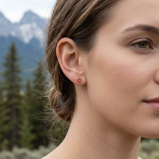 Full-body shot of a model outdoors showcasing a small silver sunstone ring on her hand amidst natural pine and mountain scenery.