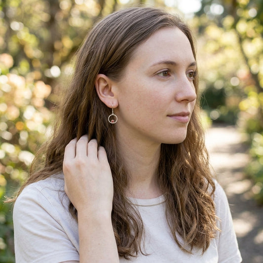 Full-body shot of a casually dressed model outdoors wearing Orbit Earrings, with natural lighting highlighting the jewelry's celestial design.