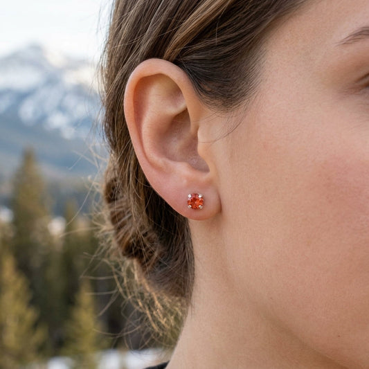 Close-up of a hand displaying a vibrant sunset orange silver sunstone ring with crisp details and natural outdoor background.