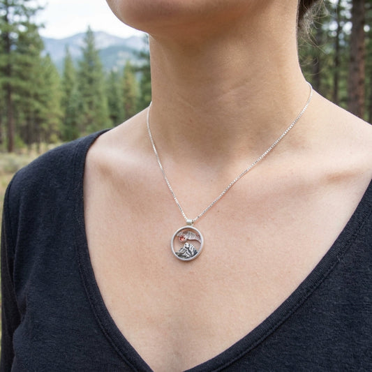 Close-up of a delicate silver chain with Oregon Mountain Pendant featuring Oregon Sunstone in a natural outdoor setting.