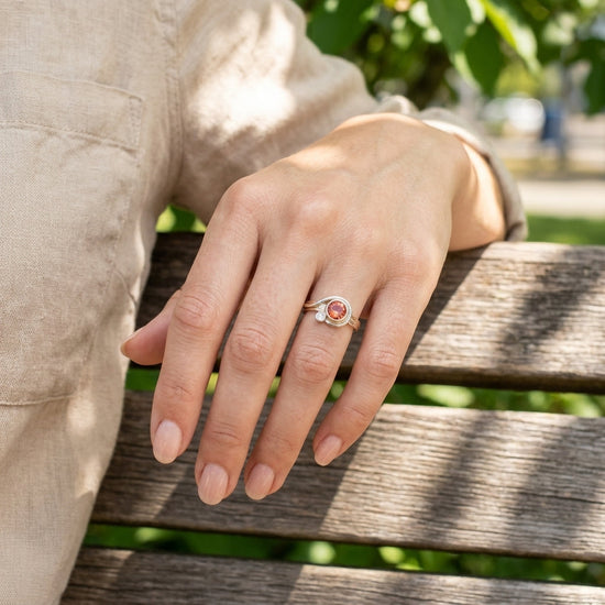 Bright outdoor scene with a model wearing a Sunstone ring on the ring finger, highlighting the delicate gold band in a natural setting.