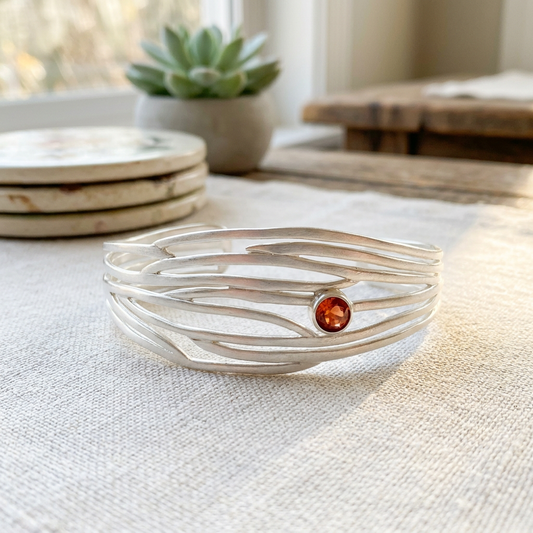Detailed side view of the Serene bracelet emphasizing its open pattern, bright sunstone, and sharp sterling silver edges.