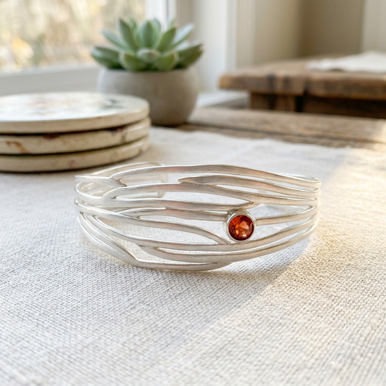 Detailed side view of the Serene bracelet emphasizing its open pattern, bright sunstone, and sharp sterling silver edges.
