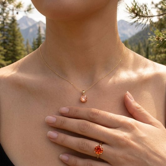 Full-body shot of a model wearing a Sunstone Necklace in a natural outdoor environment with pine trees and mountains, exuding elegance and serenity.