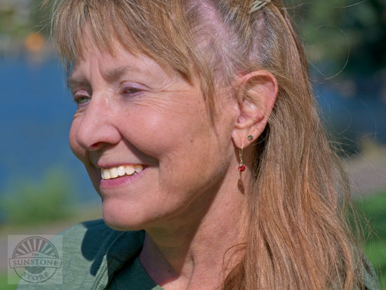 Model with green stud and sunset dangle